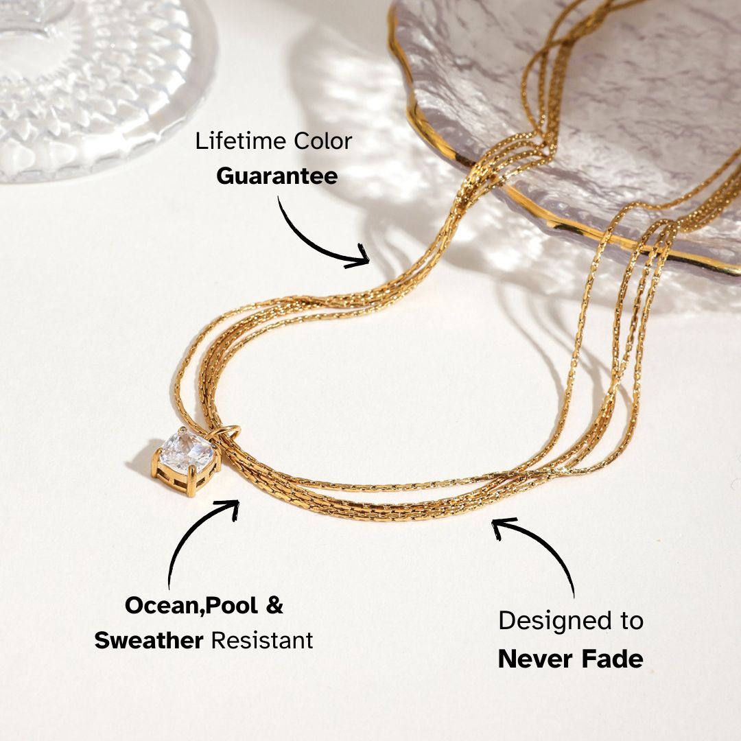 Zircon pendant gold necklace styled on tabletop with sunlight