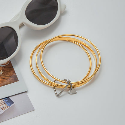 Stylish stackable bracelets with heart detail in natural light