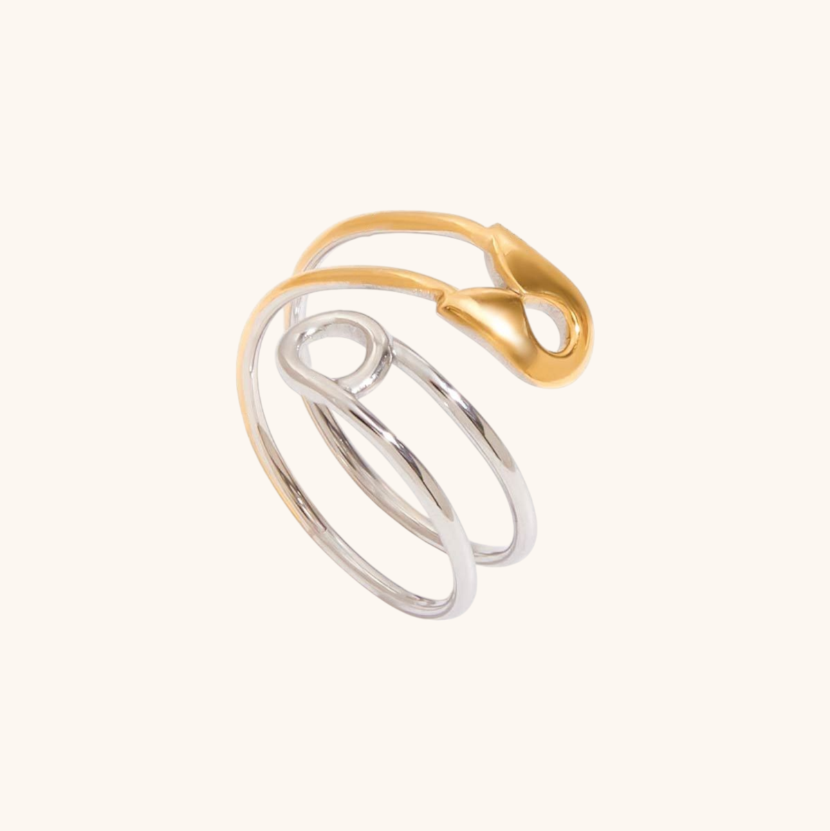 Silver and gold safety pin ring displayed on neutral background