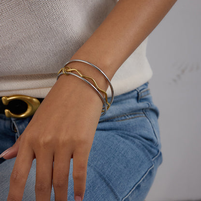 Model wearing dual-tone wave bangles with casual denim outfit