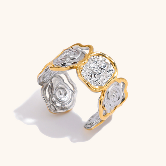 Silver and gold carved swirl open ring shot in studio on light background