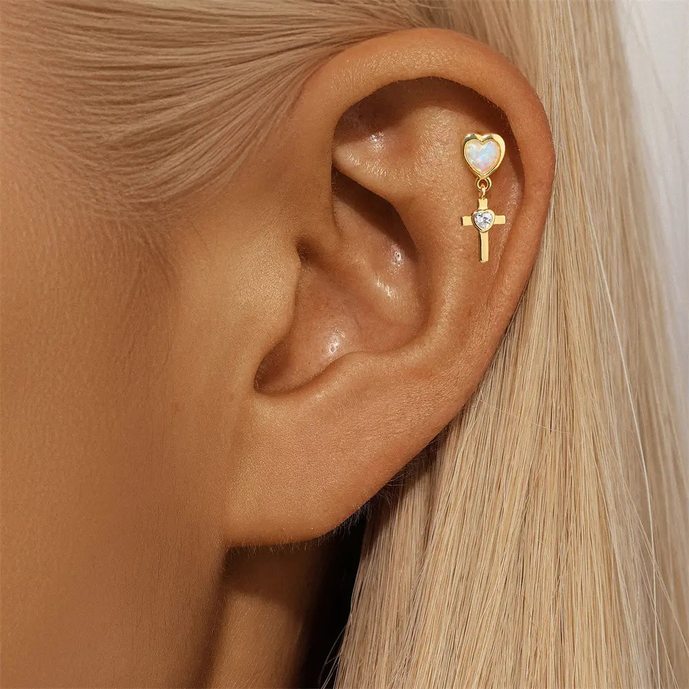 Model showcasing 925 sterling silver heart cross earrings featuring opal stones and zirconia accents, plated in 14K gold.