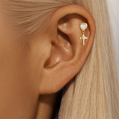 Model showcasing 925 sterling silver heart cross earrings featuring opal stones and zirconia accents, plated in 14K gold.