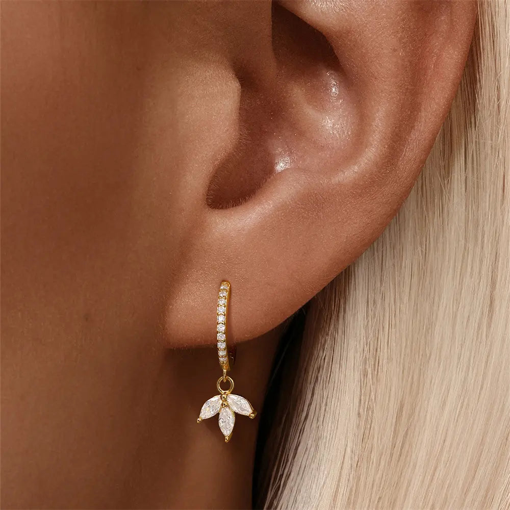 Model wearing 925 sterling silver earrings with a leaf design and cubic zirconia, adding a touch of elegance.