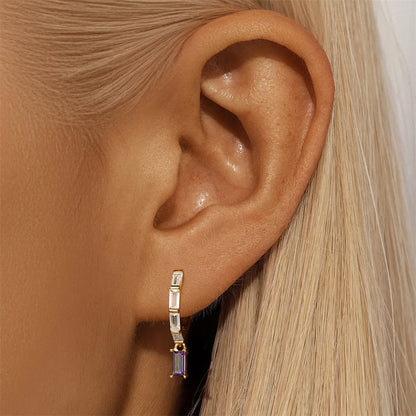 Model showcasing chic gold-plated 925 sterling silver drop earrings adorned with zirconia stones, adding a touch of elegance to any outfit.