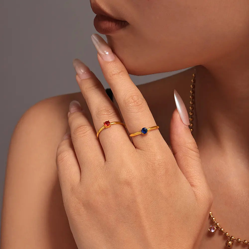Model wearing two minimalist adjustable zircon open rings in gold with colorful zircon stones.