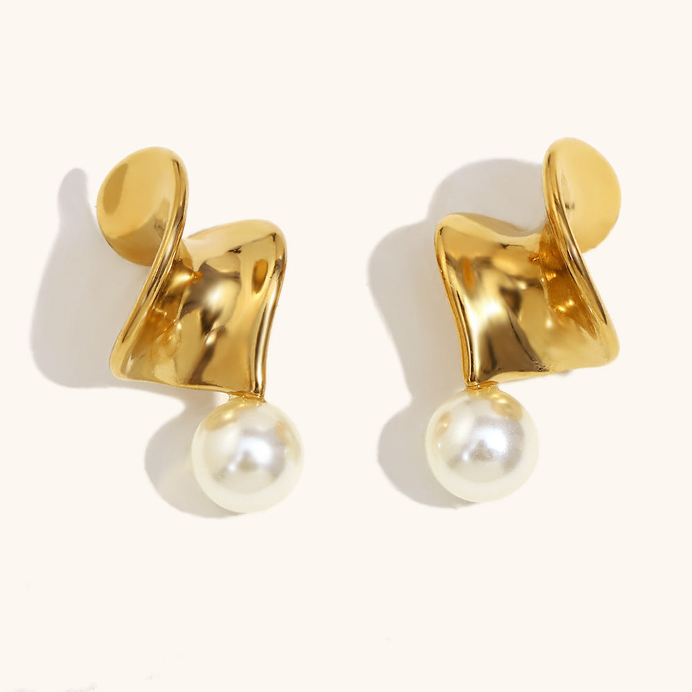 Contemporary gold earrings with pearls displayed on white background