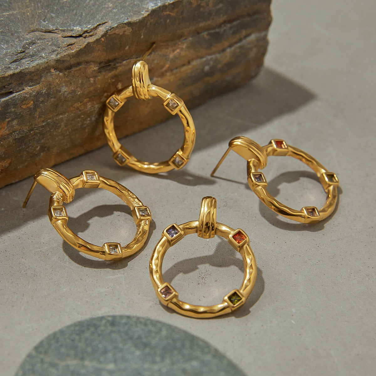 Two pairs of circular gold earrings, rainbow vs. clear crystals side-by-side