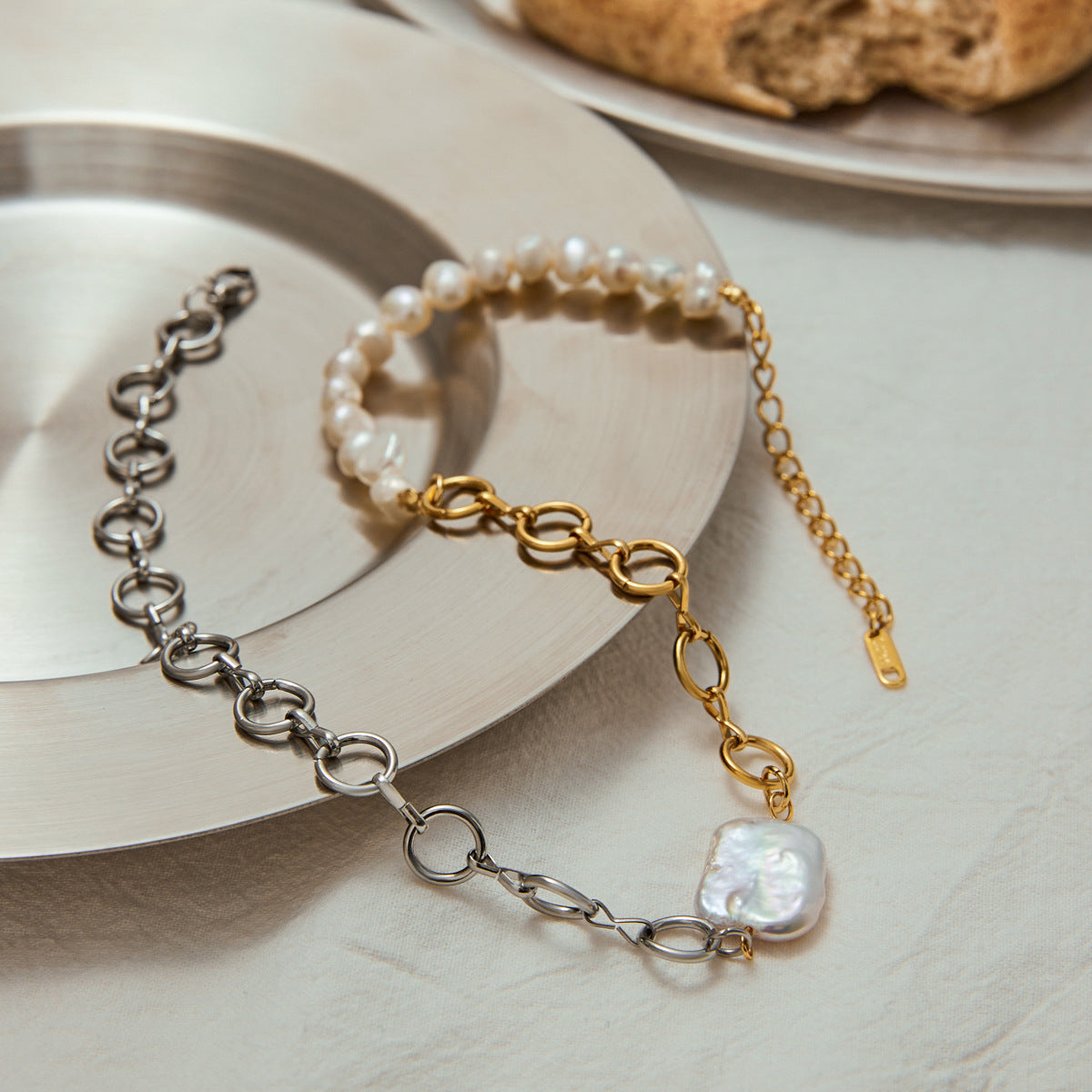 Hybrid pearl and chain necklace styled on metallic tableware, ideal for modern boho look