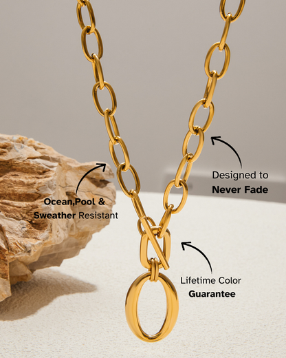 Gold chain necklace with text on durability and color guarantee, placed on a neutral background.