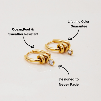 Flatlay of customizable gold hoop earrings with charm pieces