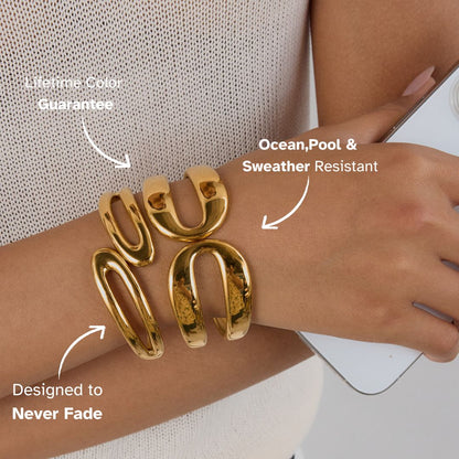 Gold bangle bracelet worn with a mesh tank, showing shine and bold design