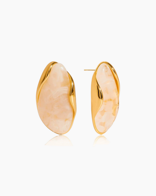 Gold earrings with a textured design on a white background
