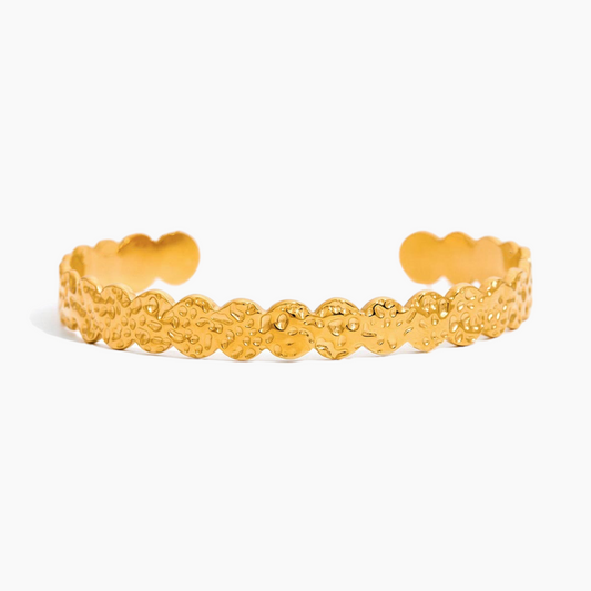 Gold bracelet with textured design on a white background