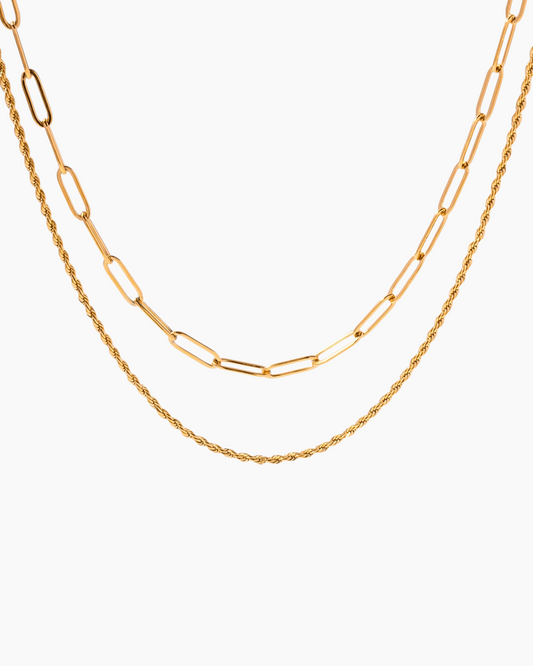 Two gold chains stacked on a white background