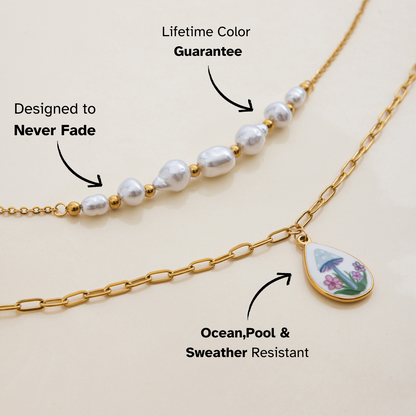 Close-up of teardrop pendant necklace with mushroom and floral enamel charm on gold chain