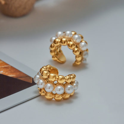 
Gold ear cuff with white pearls styled in stackable earring look