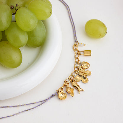 Back view of gold charm necklace showing chain detail