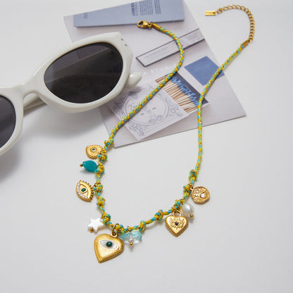 Flatlay of ocean-themed charm necklace beside sunglasses