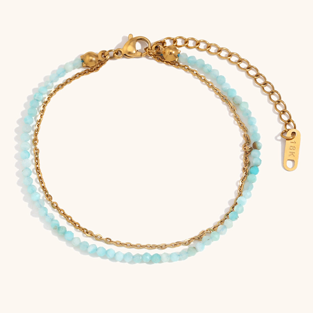 Delicate turquoise blue beaded bracelet with gold chain, perfect for beach styling.