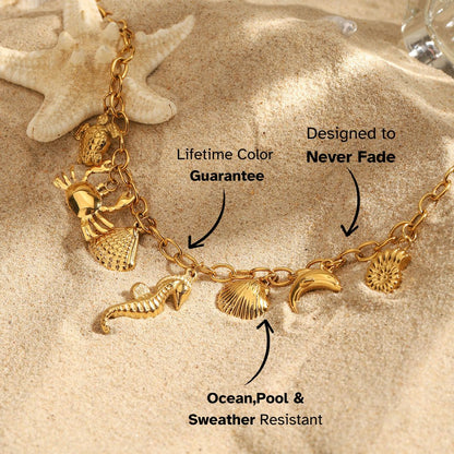 Beach scene with gold charm bracelet featuring marine animals