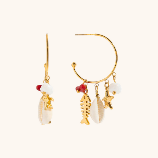 Close-up of tropical summer earrings with fishbone and star pendants