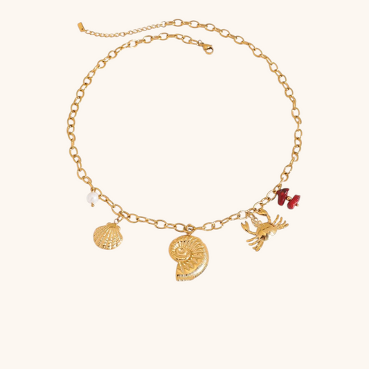 Gold ocean-themed necklace with crab, shell and pearl pendants
