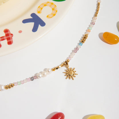 Layered jewelry set featuring pastel bead necklace and sun charm