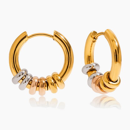 Gold hoop earrings with small cylindrical beads on a white background
