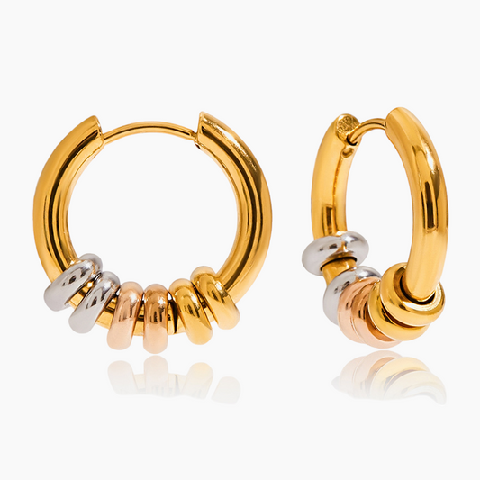 Gold hoop earrings with small cylindrical beads on a white background