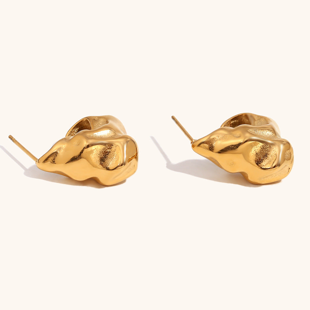 Abstract gold hoops with irregular wavy surface on display