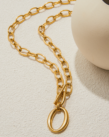 Gold chain necklace on a light beige background