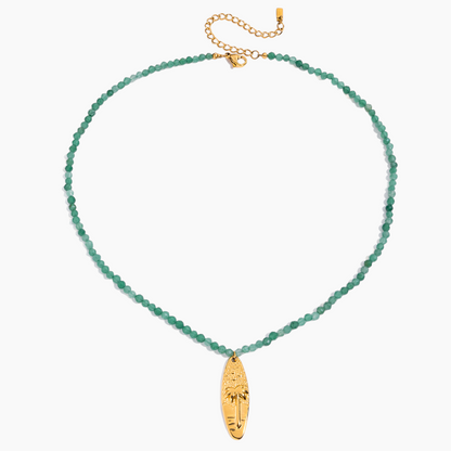 Green beaded necklace with a gold pendant on a white background