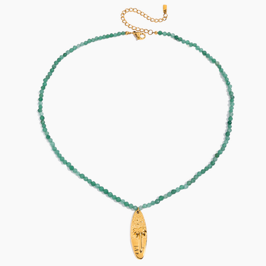 Green beaded necklace with a gold pendant on a white background