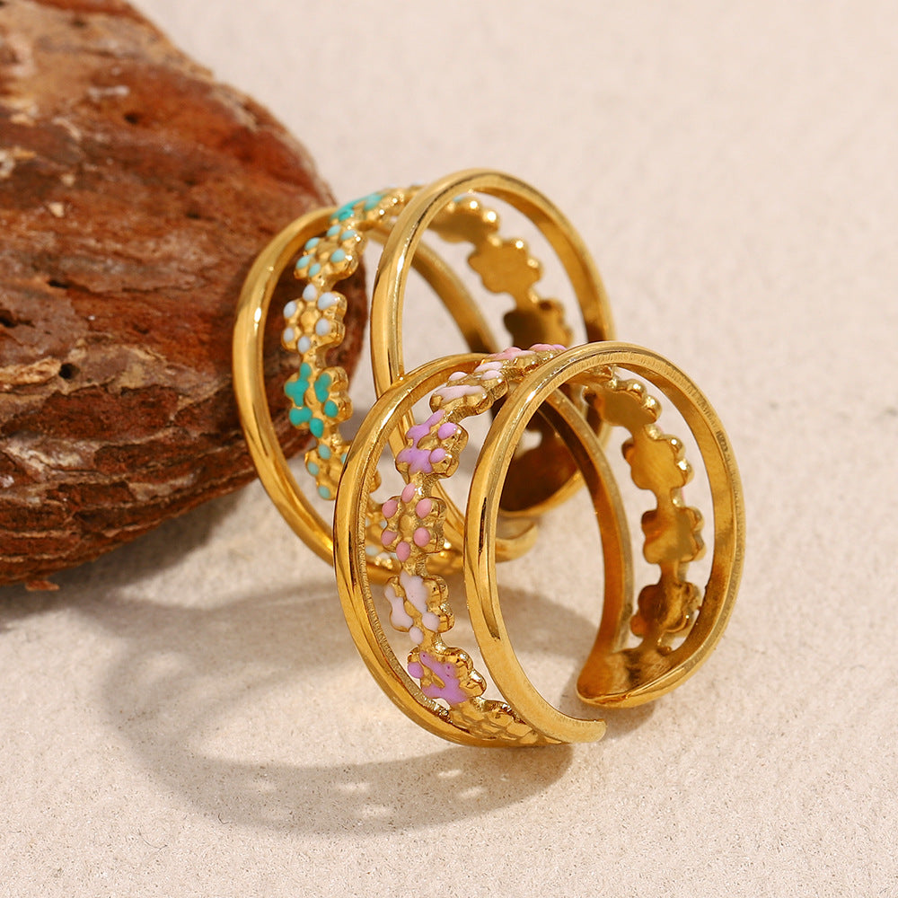 Pink enamel flower ring in open gold design, showing inner floral motif band.