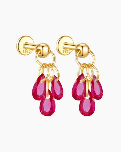 Gold earrings with pink gemstones on a white background