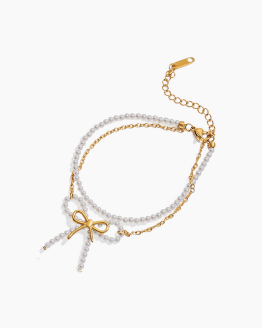 Two pearl bracelets with gold accents on a white background