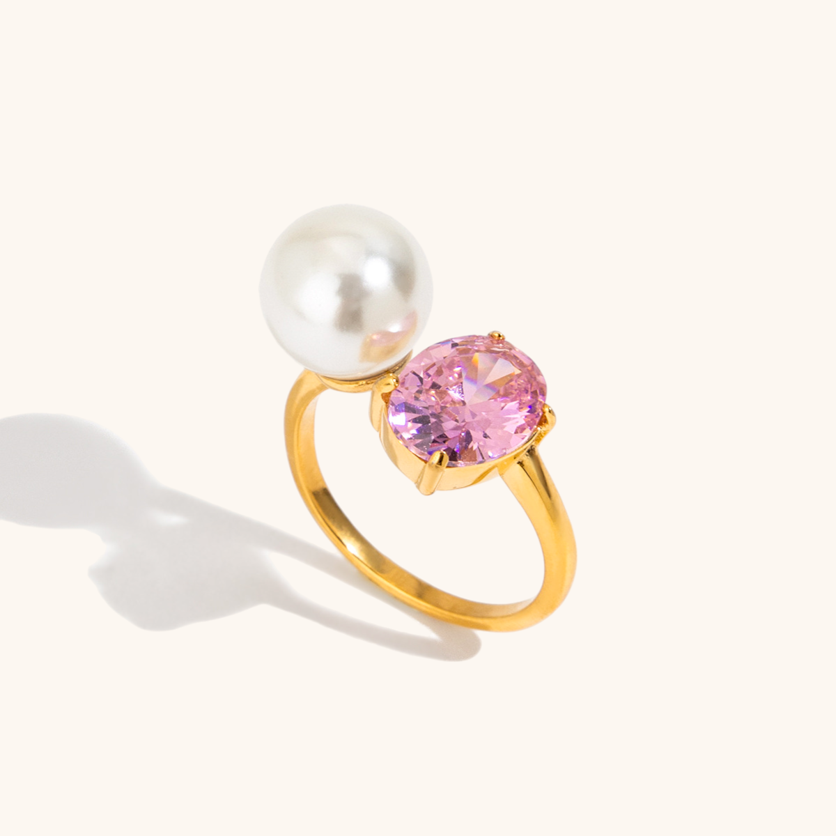 Gold ring with pearl and pink zircon on neutral background