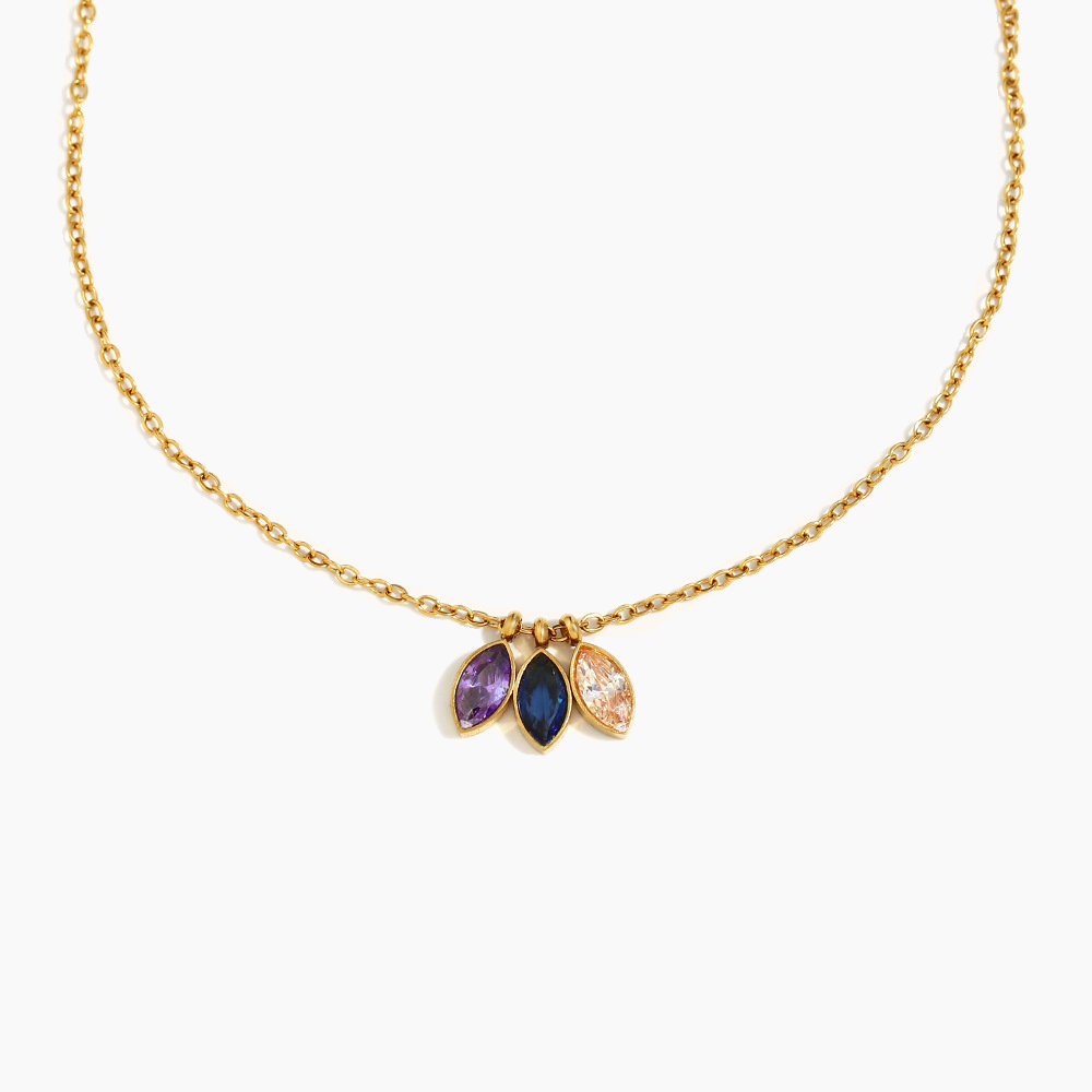 Gold necklace with three gemstones on a white background