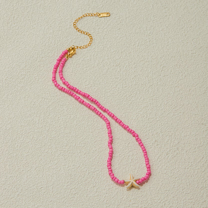 Close-up of starfish charm and pink freshwater pearls with gold accents, highlighting ocean-inspired texture.