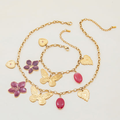 Pink and gold charm necklace flatlay with feminine beach vibe