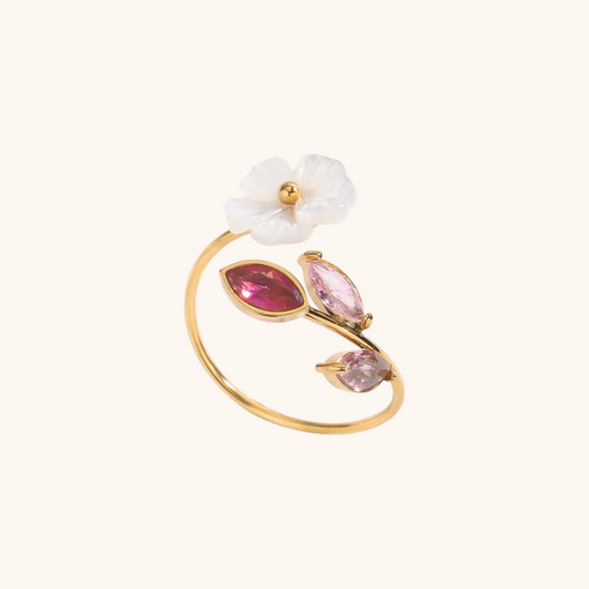 Close-up of open ring with white flower and pink navette crystals