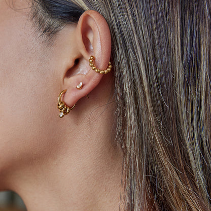 Side view of model showing stackable gold earrings in daily look