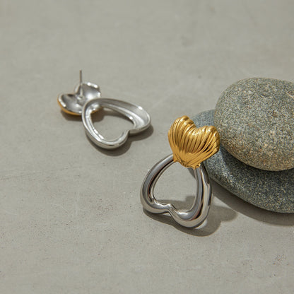 Studio product shot of minimalist sculpted heart earrings