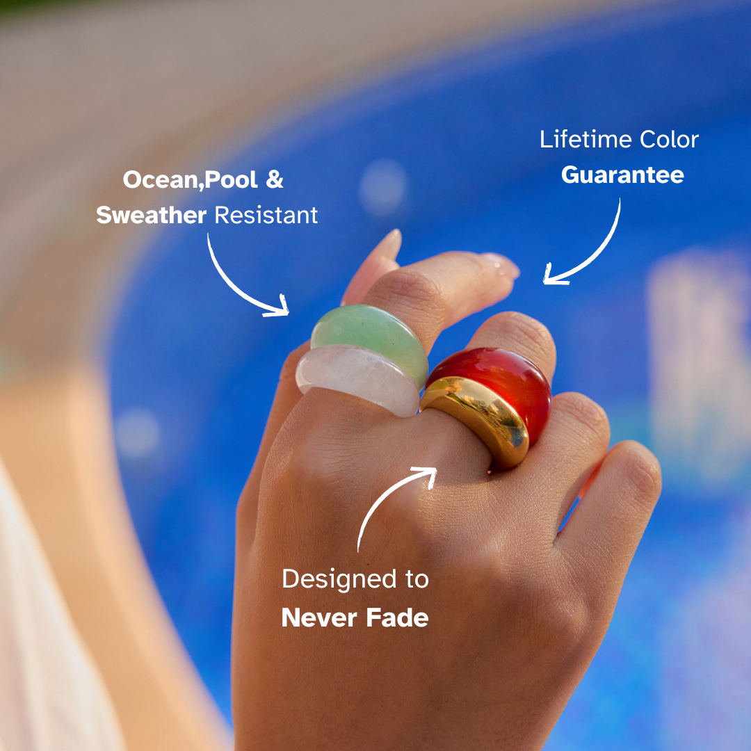 Glossy translucent resin ring on hand with pool background