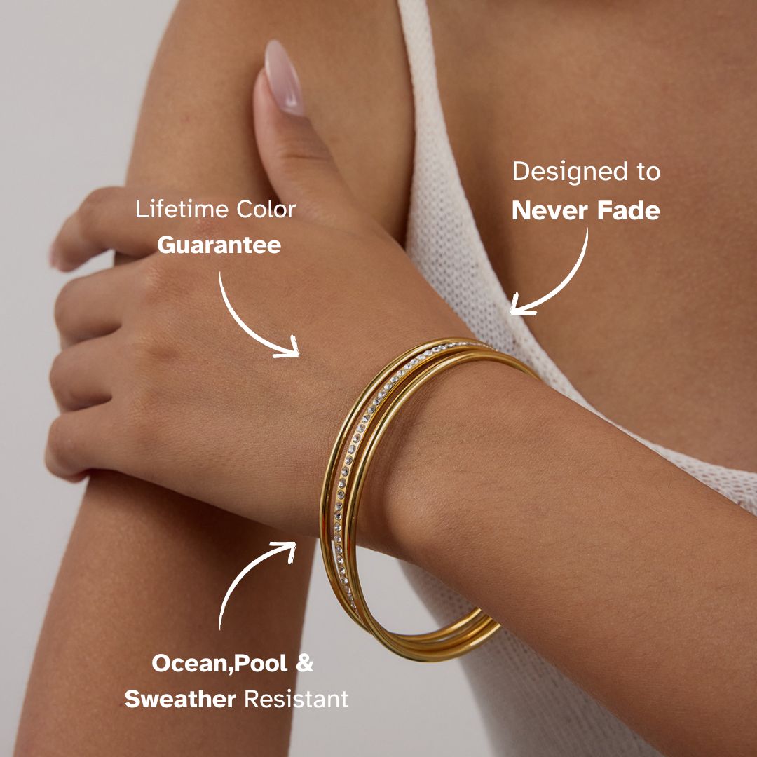 Gold bangle bracelet with crystals worn on wrist in summer outfit