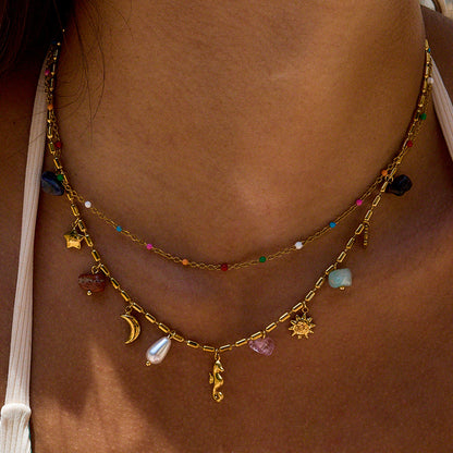Gold necklace with various charms on a person's neck