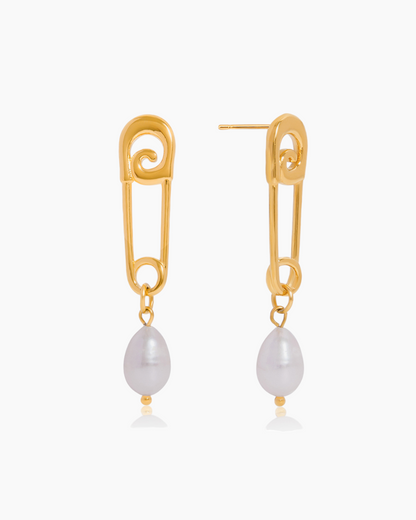 Gold safety pin earrings with pearl drops on a white background