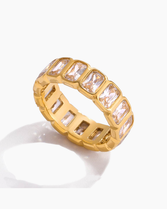 Gold ring with rectangular gemstones on a white background