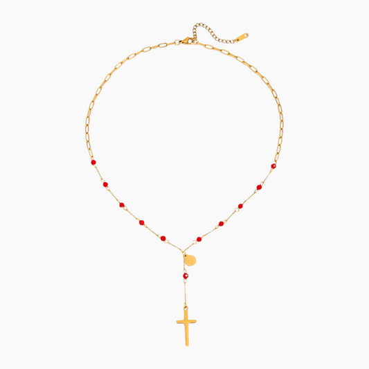 Gold necklace with red beads and a cross pendant on a white background